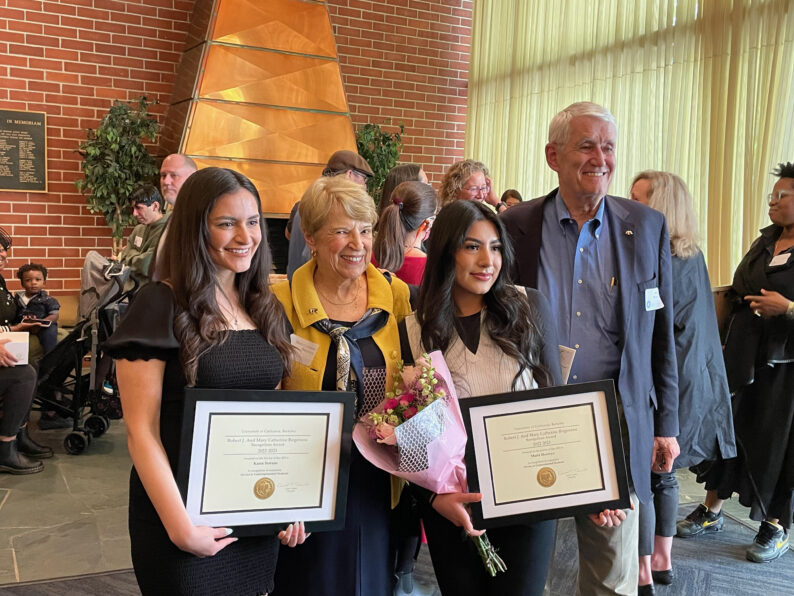 Karen Serrano stands next to Robert and Mary Catherine Birgeneau while holding a certificate she received in recognition of her service to underrepresented students